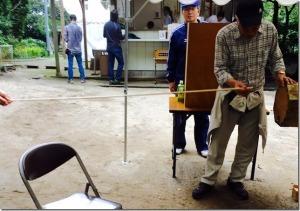 巨大おみくじから出た長い棒を手に取っている男性の写真
